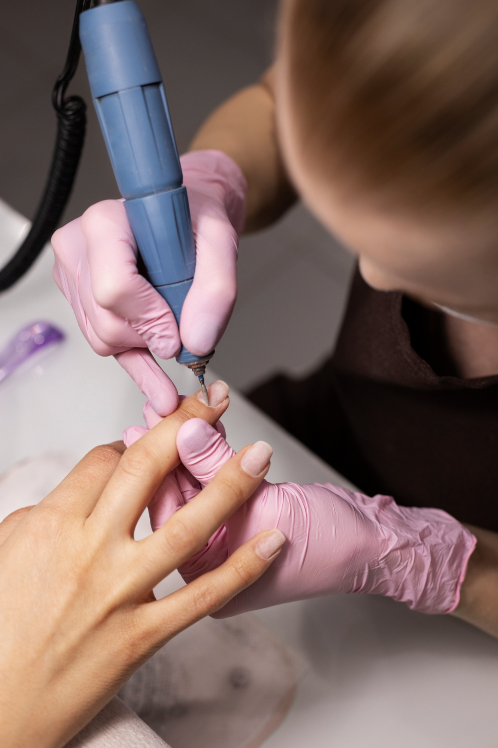 a person using a machine to remove nails