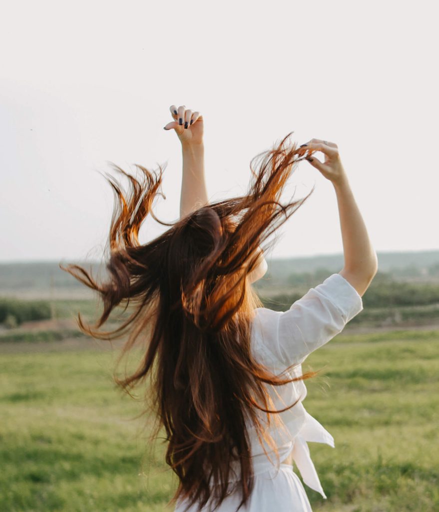 carefree-long-hair-girl-in-white-clothes-on-field-JNDR92V-879x1024