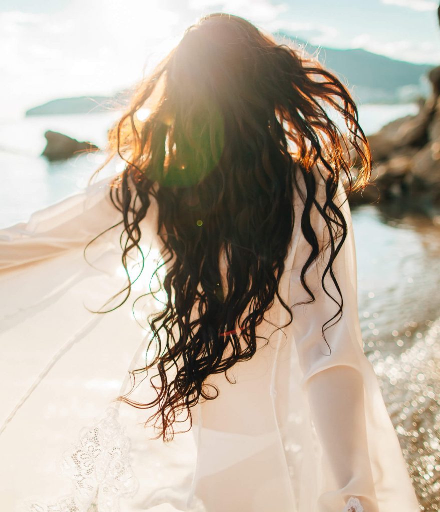 wind-in-hair-dreamy-girl-with-sunflare-on-beach-CLH3HZB-879x1024 (1)